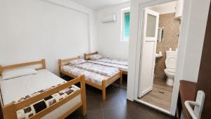 a bedroom with two beds and a bathroom at Motel MEČE in Bijelo Polje
