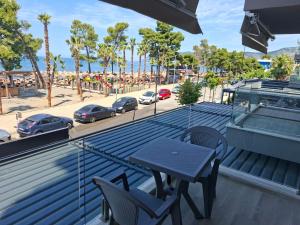 a table and chairs on a roof with a view of a beach at D&D hotel in Shëngjin