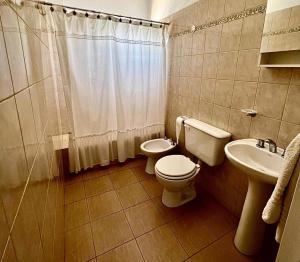 a bathroom with a toilet and a sink at OLÍMPICO in Concepción del Uruguay