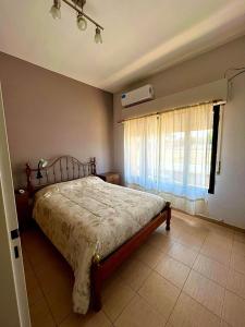 a bedroom with a bed and a window with a fan at OLÍMPICO in Concepción del Uruguay