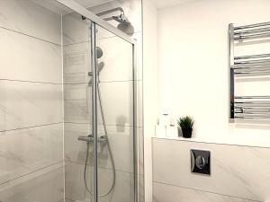 a bathroom with a shower with a glass door at Goodmayes Grand Hotel in Goodmayes