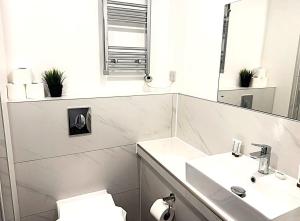 a bathroom with two sinks and a mirror at Goodmayes Grand Hotel in Goodmayes