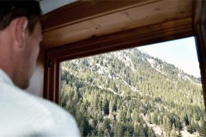 a man looking out a window at a mountain at Mountain Lodge Stubai in Neustift im Stubaital