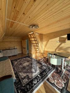 a living room with a wooden ceiling and a staircase at D&N Karakol in Karakol