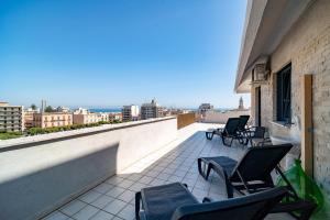 a balcony with chairs and a view of a city at La Quintessenza in Monopoli