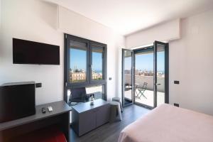 a bedroom with a bed and a flat screen tv at La Quintessenza in Monopoli