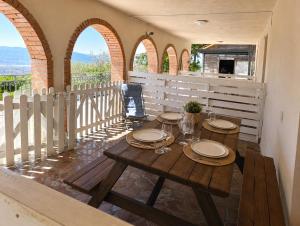 a table with plates and wine glasses on a balcony at Fattoria Cristina Family Duplex with Pool, Panoramic Terrace & Farm Animals - Bilo Rosa in Castelnuovo Magra