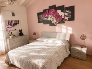 a bedroom with a bed and flowers on the wall at Fattoria Cristina Family Duplex with Pool, Panoramic Terrace & Farm Animals - Bilo Rosa in Castelnuovo Magra