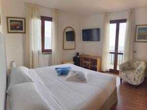 a bedroom with a bed and a chair and a television at Ca Vecia in Gargnano