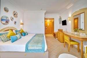 a hotel room with a bed and a desk at Medina Les Quatre Saisons Aqua Park Resort and Thalasso Djerba in Djerba