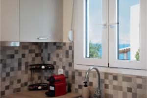 a kitchen counter with a sink and a window at Exis Seaview in Vathí +16 photos