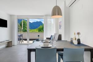 a dining room and living room with a table and chairs at Bike Apartments Curti - Himmelblau in Laives