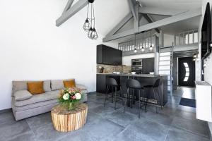 a living room and kitchen with a couch and a table at Cozy Cottage with Spa - Welkeys in Moliets-et-Maa