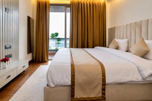 a bedroom with a large bed and a large window at Evaara By The Ganges A Ganga Access Resort & Jungle Safari in Haridwār