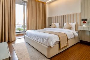 a bedroom with a large bed and a large window at Evaara By The Ganges A Ganga Access Resort & Jungle Safari in Haridwār