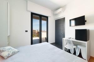 a bedroom with a bed and a desk with a television at La Quintessenza in Monopoli