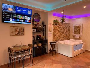 a room with a tub and a tv on the wall at Room24 Relax & Wellness in Genzano di Roma