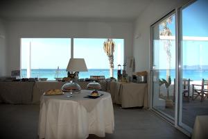 a room with a table with a view of the ocean at Lido Di Alghero Beach Resort in Alghero