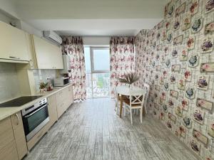 a kitchen with a table and a dining room at RentDay Botanica in Chişinău