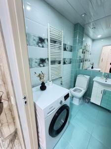 a bathroom with a washing machine and a toilet at RentDay Botanica in Chişinău +10 photos