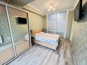 a small bedroom with a bed and a sliding glass door at RentDay Botanica in Chişinău