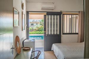 a bedroom with a bed and a door to a pool at Villa Leda - The Guest Wing in Paphos