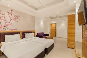 a hotel room with two beds and a chair at Country Inn Smart Stays, Patna in Patna