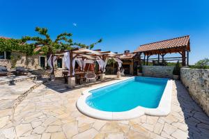 a swimming pool in a yard with a gazebo at My Dalmatia - Hilltop Paradise with private pool, sauna and Jacuzzi in Kula Atlagić