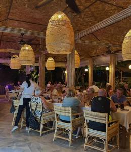 a group of people sitting at tables in a restaurant at Röstiland by NOXAMA SAMUI in Lamai