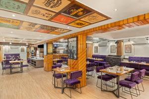 a dining room with tables and purple chairs at Country Inn Smart Stays, Patna in Patna