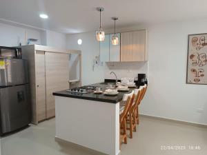 a kitchen with a counter and a stove top oven at Apartamentos Quedate en Anavi San Gil Plaza in San Gil