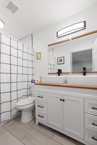 a bathroom with a toilet and a sink and a mirror at Mins to Downtown Chic & Modern - Elegant in Noir in Chattanooga