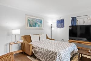 a living room with a bed and a flat screen tv at Mins to Downtown Chic & Modern - Elegant in Noir in Chattanooga +26 photos