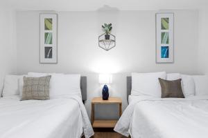 two white beds in a room with two windows at Mins to Downtown Chic & Modern - Elegant in Noir in Chattanooga