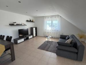a living room with a couch and a television at Ferienwohnung in Staufenberg- Treis in Staufenberg