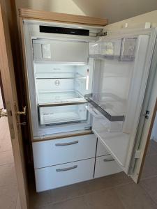 an empty refrigerator with its door open in a kitchen at Ferienwohnung in Staufenberg- Treis in Staufenberg