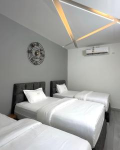 a room with three beds and a clock on the wall at bh villa in Al Sharqiyah +23 photos