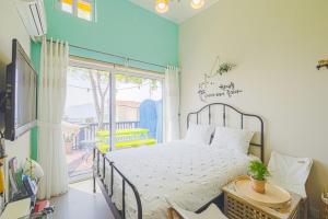 a bedroom with a bed and a large window at Namhae arahil pension in Namhae