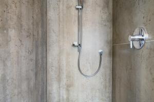 a shower with a shower head on a wall at Bike Apartments Curti - Abendrot in Laives +25 photos