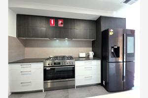 a kitchen with a stove and a refrigerator at Baldivis Retreat in Baldivis