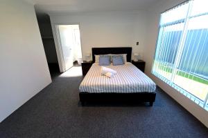 a bedroom with a bed and a large window at Baldivis Retreat in Baldivis
