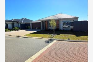 a house with a tree on the side of the road at Baldivis Retreat in Baldivis