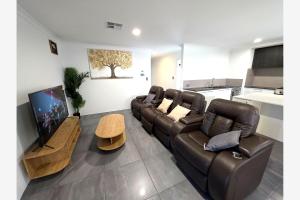 a living room with a couch and a flat screen tv at Baldivis Retreat in Baldivis