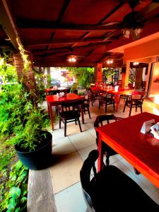 a restaurant with red tables and chairs and plants at Hotel Uke Inn Terán in Tuxtla Gutiérrez