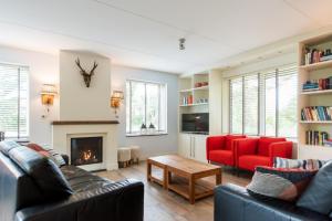 a living room with two couches and a fireplace at Alegria, ruime familievilla voor 9 personen in Ballum