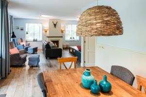 a dining room and living room with a table with vases on it at Alegria, ruime familievilla voor 9 personen in Ballum