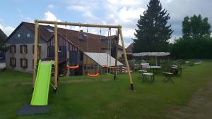 a swing set in a yard in front of a house at Maison d'hôtes - Relais De La Poste in Gerbépal