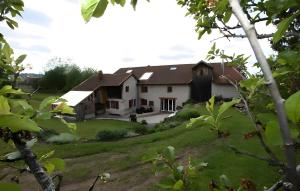 a house on a hill with a green yard at Maison d'hôtes - Relais De La Poste in Gerbépal