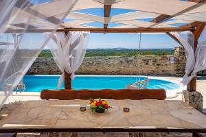 a room with a view of a pool with a swing at My Dalmatia - Hilltop Paradise with private pool, sauna and Jacuzzi in Kula Atlagić