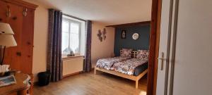 a small bedroom with a bed and a window at Maison d'hôtes - Relais De La Poste in Gerbépal